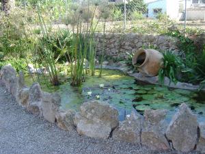 The mediterranean garden is beautifully taken care of, and includes a pond and water feature.